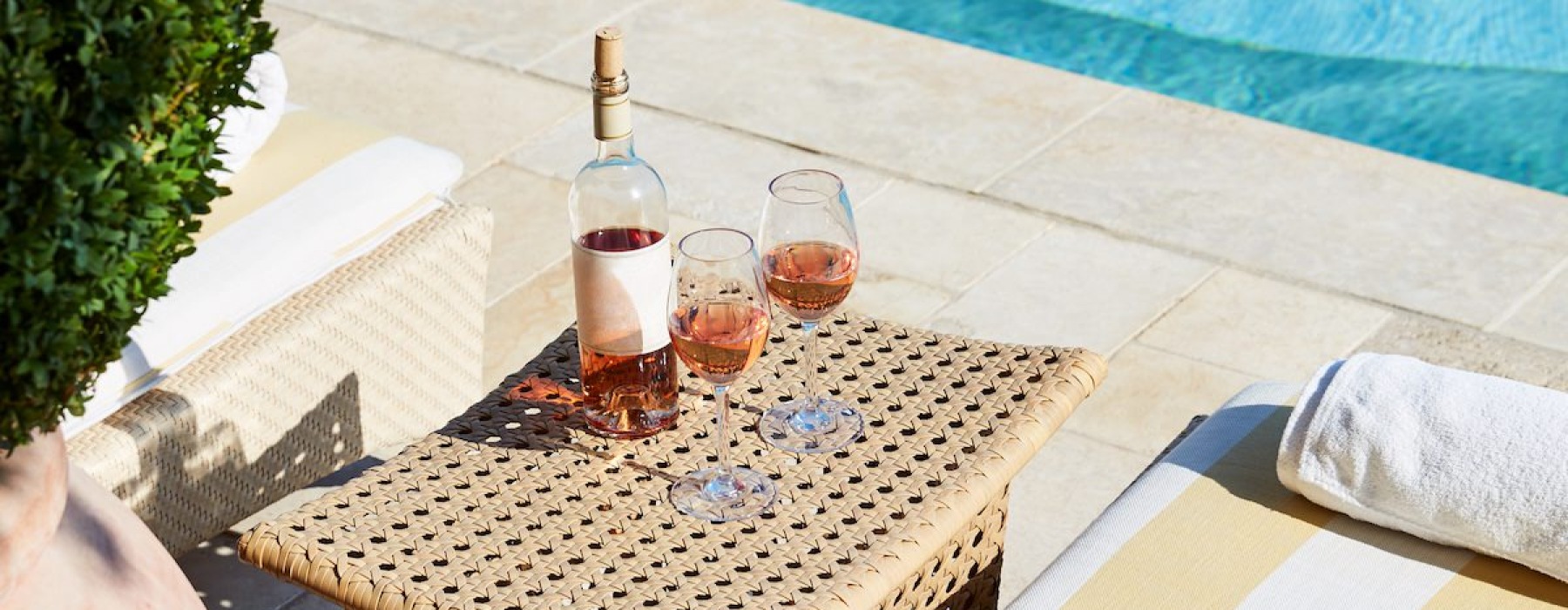 a table with glasses and bottles on it by a pool